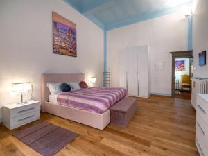 een slaapkamer met een bed met een paars dekbed bij Pitti Mannelli Suite in Florence