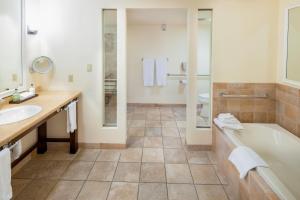 a bathroom with a tub and a toilet and a sink at The Quail Lodge in Carmel