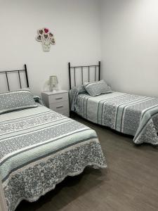 コニル・デ・ラ・フロンテーラにあるApartamento Conil Playaの寝室に並んで置かれた2つのベッド
