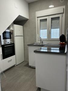 a kitchen with white appliances and a counter top at Apartamento Conil Playa in Conil de la Frontera