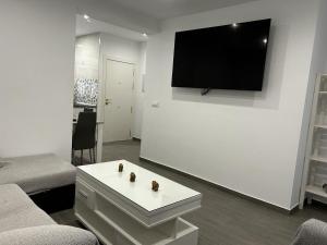 a living room with a tv on a white wall at Apartamento Conil Playa in Conil de la Frontera