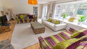 sala de estar con 2 sofás y TV en Shippenrill Croyde - Sleeps 14 - Hot Tub option - Stylish Home with fire pit, table tennis & dog friendly, en Croyde