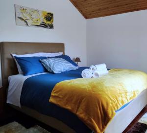 uma cama com lençóis e toalhas azuis e amarelos em Casa das Camélias em Viseu