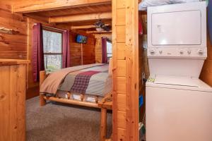 1 dormitorio en una cabaña de madera con 1 cama y nevera en Peaceful Haven en Sevierville