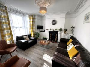 a living room with a leather couch and a fireplace at 4 Bed in Brixham 90449 in Brixham
