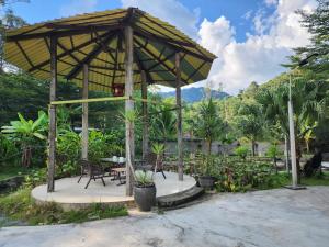 a gazebo with a table and chairs at Rock Forest Chalet in Bentong