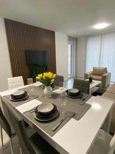 un comedor con una mesa con platos y vasos en ATEA Apartments, en Kavarna