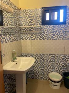 uma casa de banho com um lavatório e um WC em Diabir em Ziguinchor