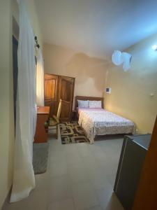 ein kleines Schlafzimmer mit 2 Betten und einem Fenster in der Unterkunft Diabir in Ziguinchor