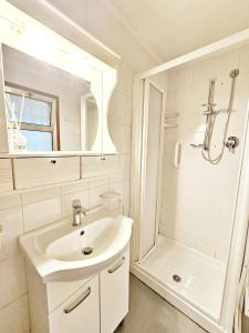 een witte badkamer met een wastafel en een douche bij AMA Ferrara in Ferrara