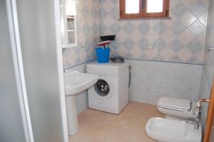 y baño con lavadora y lavamanos. en Rifinito appartamento con veranda vista mare a Maladroxia C65 en Maladroxia