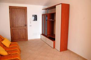 een woonkamer met een bank en een entertainmentcentrum bij Rifinito appartamento con veranda vista mare a Maladroxia C65 in Maladroscia