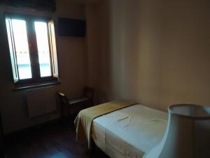 a small bedroom with a bed and a window at Hotel Cabo Ortegal in Cariño