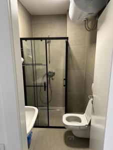 ein Badezimmer mit Dusche, Toilette und Waschbecken in der Unterkunft Apartment Niš in Niš