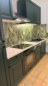 eine Küche mit grünen Schränken und einem Muster an der Wand in der Unterkunft Wohnung im Zentrum von Essen in Essen
