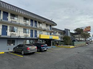 Dos coches estacionados en un estacionamiento frente a un edificio. en Days Inn by Wyndham El Paso Airport East, en El Paso