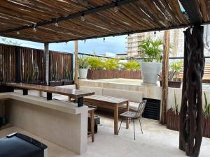 a patio with a wooden table and a table and chairs at BULUC LUCH PH para grupos con Roof top y alberca privada in Tulum