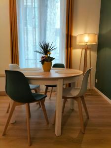 a dining room table and chairs with a plant on it at Appartement de charme 1h de Paris in Coulommiers