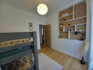 a bedroom with a bed and a room with shelves at Appartement de charme 1h de Paris in Coulommiers