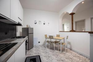 cocina blanca con mesa y nevera en Casa Malu', en Legnano