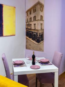 een witte tafel met roze borden en een fles wijn bij Pitti Mannelli Suite in Florence