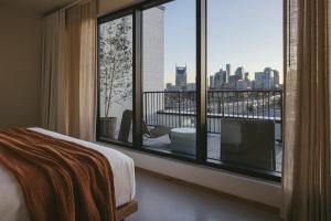 納許維爾的住宿－Drift Nashville，卧室设有大窗户,享有城市美景