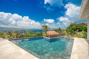 a swimming pool with a view of the ocean at Tangarane in Les Trois-Îlets