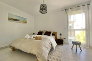 Un dormitorio blanco con una cama grande y una ventana en Bright apartment with balcony, en Montpellier