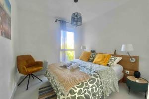 1 dormitorio con 1 cama, 1 silla y 1 ventana en Bright apartment with balcony, en Montpellier