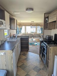 an rv kitchen with a stove and a living room at Caravan sleeps 8 at Littlesea, Weymouth in Wyke Regis