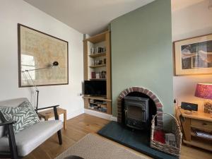 a living room with a fireplace and a chair at Spa Cottage in Braithwaite