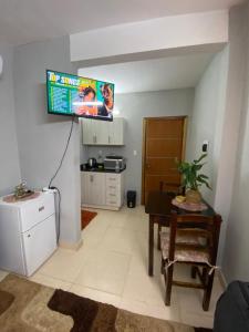 sala de estar con mesa y TV en la pared en Lujoso ,cómodo MONOAMBIENTE, en San Lorenzo