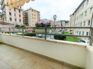 een balkon met potbloemen op een richel bij A casa di Ezio e Paola in La Spezia