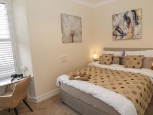 um quarto com uma cama com um urso de peluche em 85C Bongate em Jedburgh