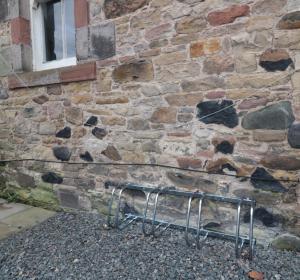 um suporte de metal em frente a uma parede de pedra em 85C Bongate em Jedburgh