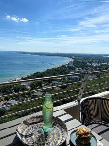 a table with a sandwich and a glass bottle on a balcony at Premium Ferienwohnung mit Meerblick in Timmendorfer Strand
