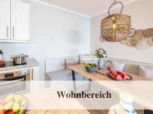 a kitchen with a table with a bowl of fruit on it at Premium Ferienwohnung mit Meerblick in Timmendorfer Strand