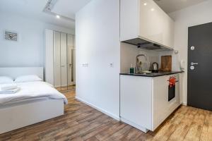 a bedroom with a bed and a small kitchen at Janasa Comfort Studio in Katowice