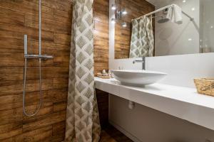 La salle de bains est pourvue d'un lavabo et d'une douche. dans l'établissement Janasa Comfort Studio, à Katowice