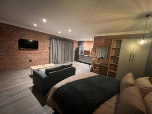 a bedroom with a bed and a couch in a room at Lemon Tree Guest House in Aliwal North