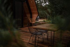 une table en bois et deux chaises sur une terrasse dans l'établissement Samosiejka - Lewy Brzeg Narwi, à Burlaki