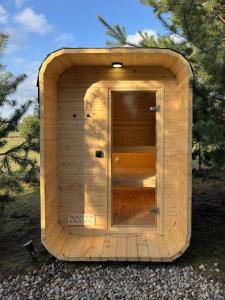 een houten sauna met een deur in het midden bij Samosiejka - Lewy Brzeg Narwi in Burlaki