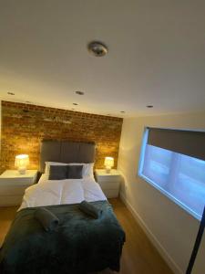 1 dormitorio con cama y pared de ladrillo en Studio apartment near Sutton, Croydon, en Banstead