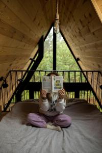 een meisje op een bed dat een boek leest bij Samosiejka - Lewy Brzeg Narwi in Burlaki