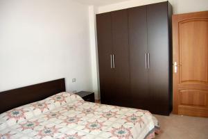 sypialnia z łóżkiem i drewnianą szafką w obiekcie Appartamento di nuova costruzione con veranda vista mare a Maladroxia C66 w mieście Maladroscia