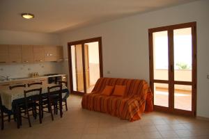 ein Wohnzimmer mit einem Sofa und einem Tisch mit Stühlen in der Unterkunft Appartamento di nuova costruzione con veranda vista mare a Maladroxia C66 in Maladroscia