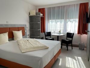 Schlafzimmer mit einem Bett, einem Tisch und Stühlen in der Unterkunft Hotel Frankenhöhe in Aurach