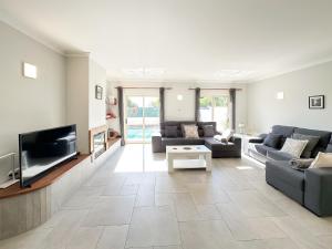 a living room with couches and a tv at Villa Primavera in Lagos