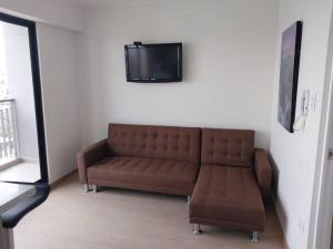 un soggiorno con divano e TV a parete di Departamento en Cayma ad Arequipa