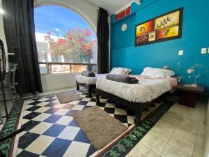 a bedroom with two beds and a blue wall at Habitación doble Hotel Chapultepec-Americana in Guadalajara